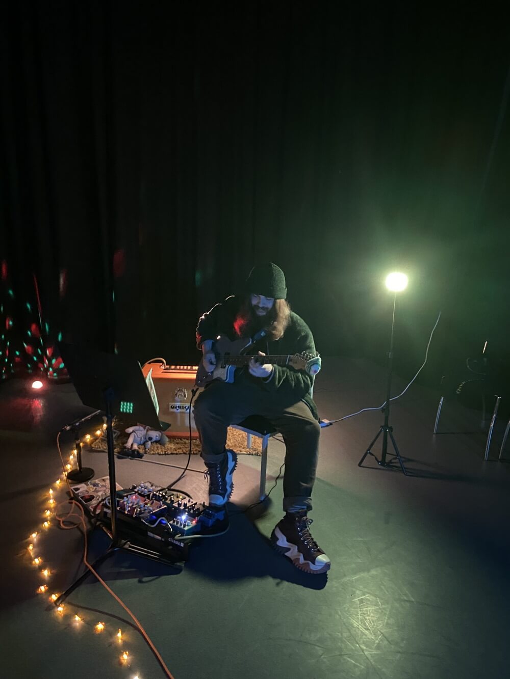 Elliot performing Solace under green stage light