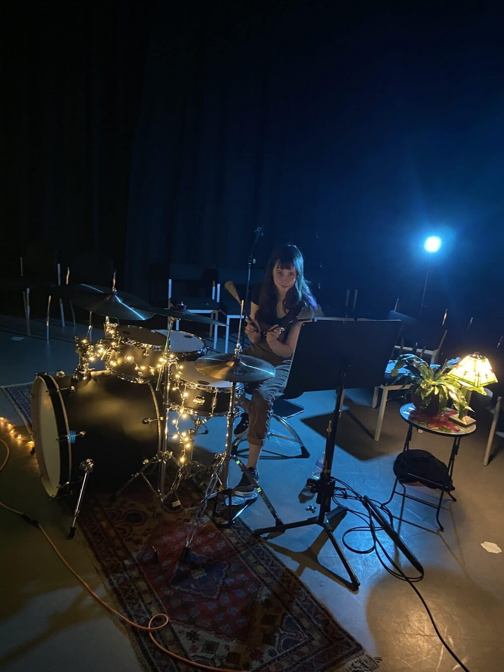 Selina performing Solace on drums under blue light
